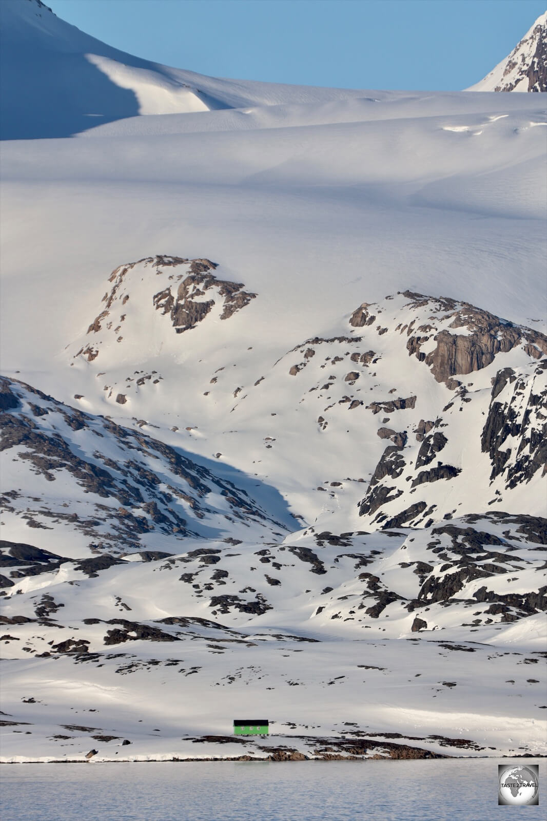 A summer house near Maniitsoq is dominated by the white expanse of the Greenland Ice Sheet.