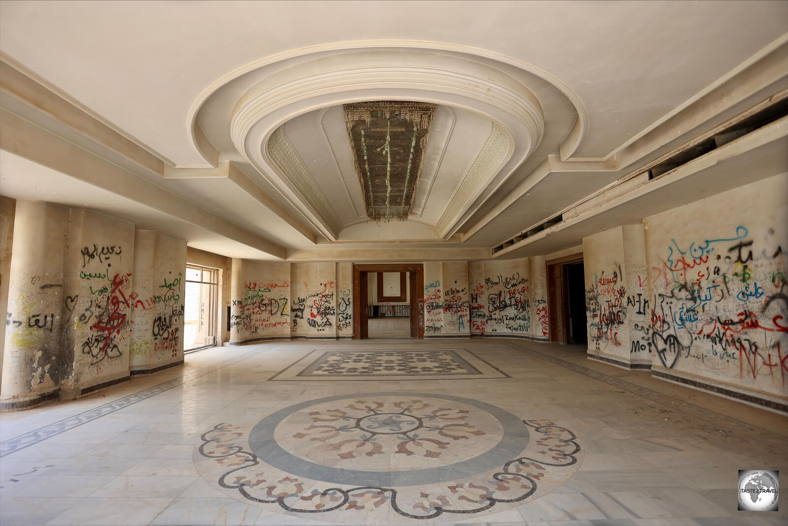 A former dining hall, with marble-mosaic floors, and walls covered in graffiti, inside Saddam's Babylon Palace.