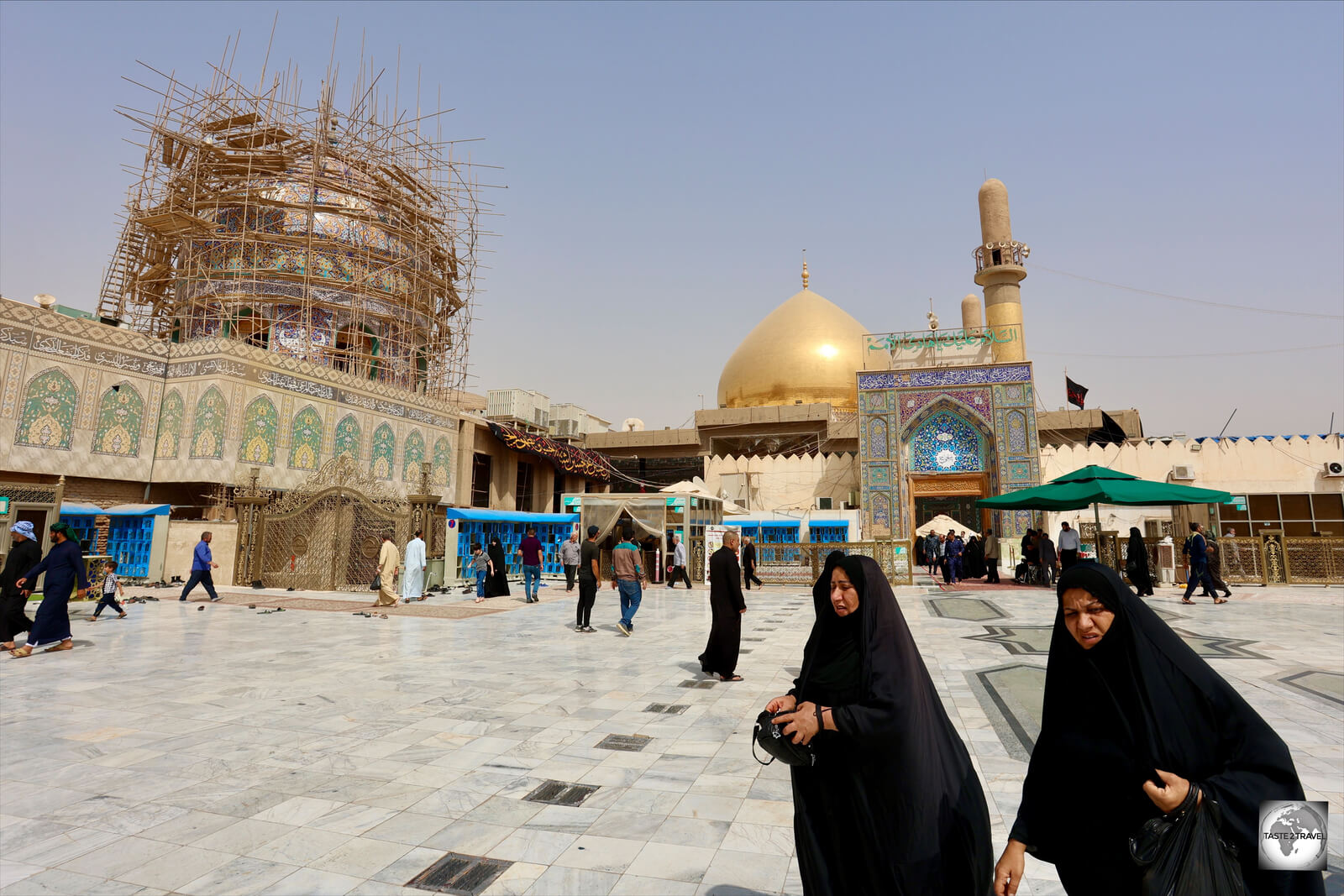 Shia pilgrims, outside the Al-Askari Mosque in Samarra, with the newly rebuilt golden dome in the background.
