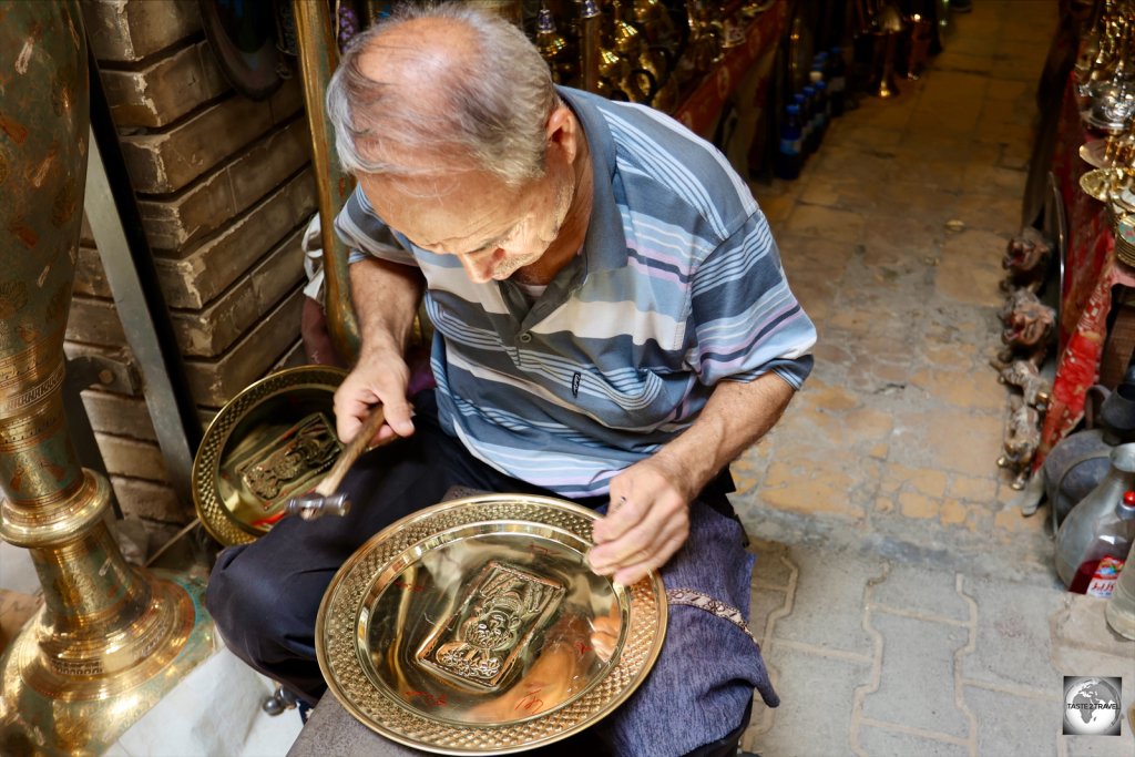 An artisan engraving a copper platter at the al-Safafeer copper market in Baghdad.