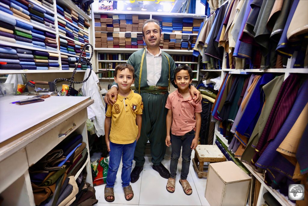 A tailor, with his two sons, inside Erbil souk.