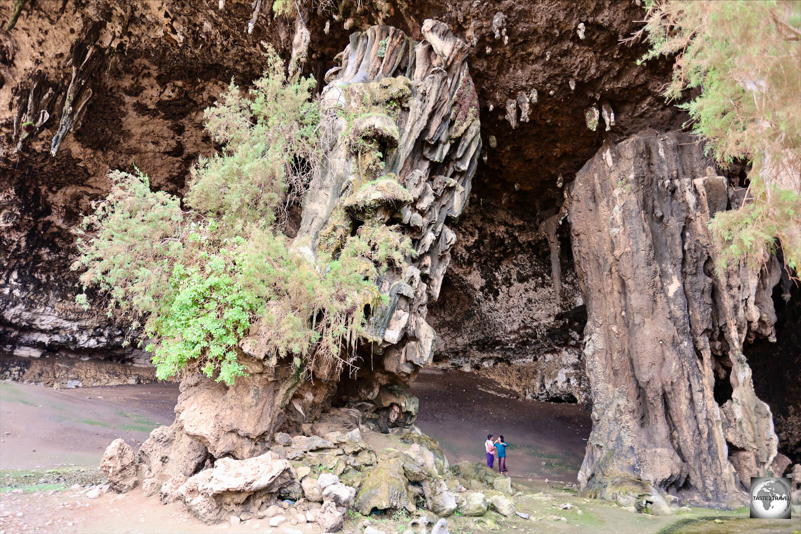 Standing in the entrance of Dagub cave, Ali and Mohammed provide a sense of scale for the two gigantic columns inside the cave.
