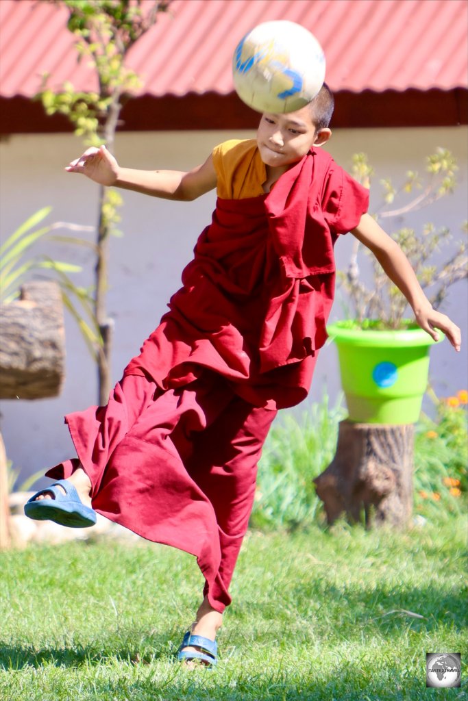 A monk playing football at Khuruthang Lhakhang.