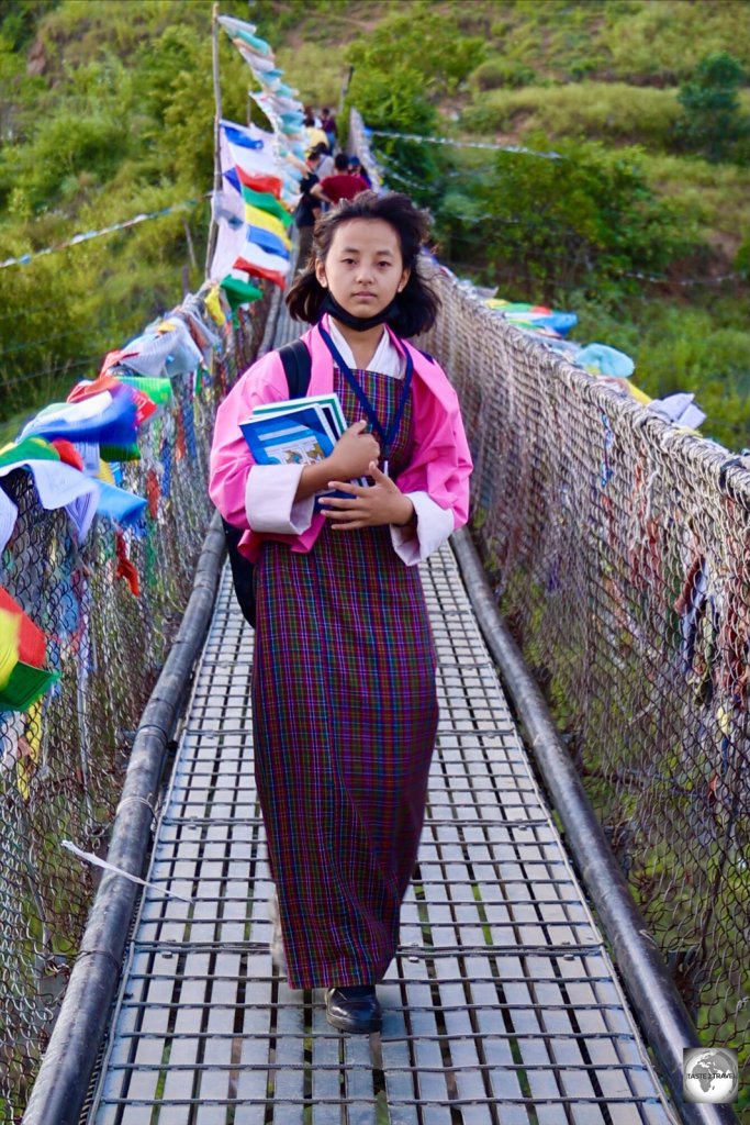 A school student, on her way home, crossing the Punakha suspension bridge,