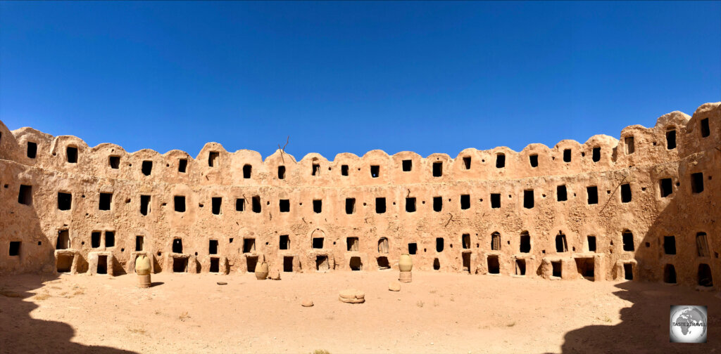 A panoramic view of Gasr Al-Hājj, a large, circular-shaped, fortified granary in the desert.