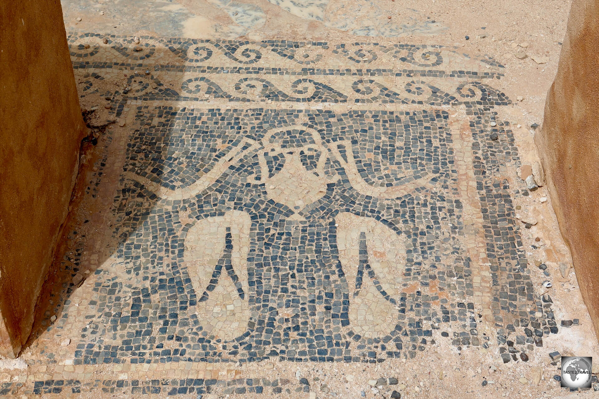 A mosaic at the entrance to a bathhouse displays sandals, olive oil (used for massage) and a pair of <i>strigils</i>, which were used for scrapping off dirt, perspiration, and oil.