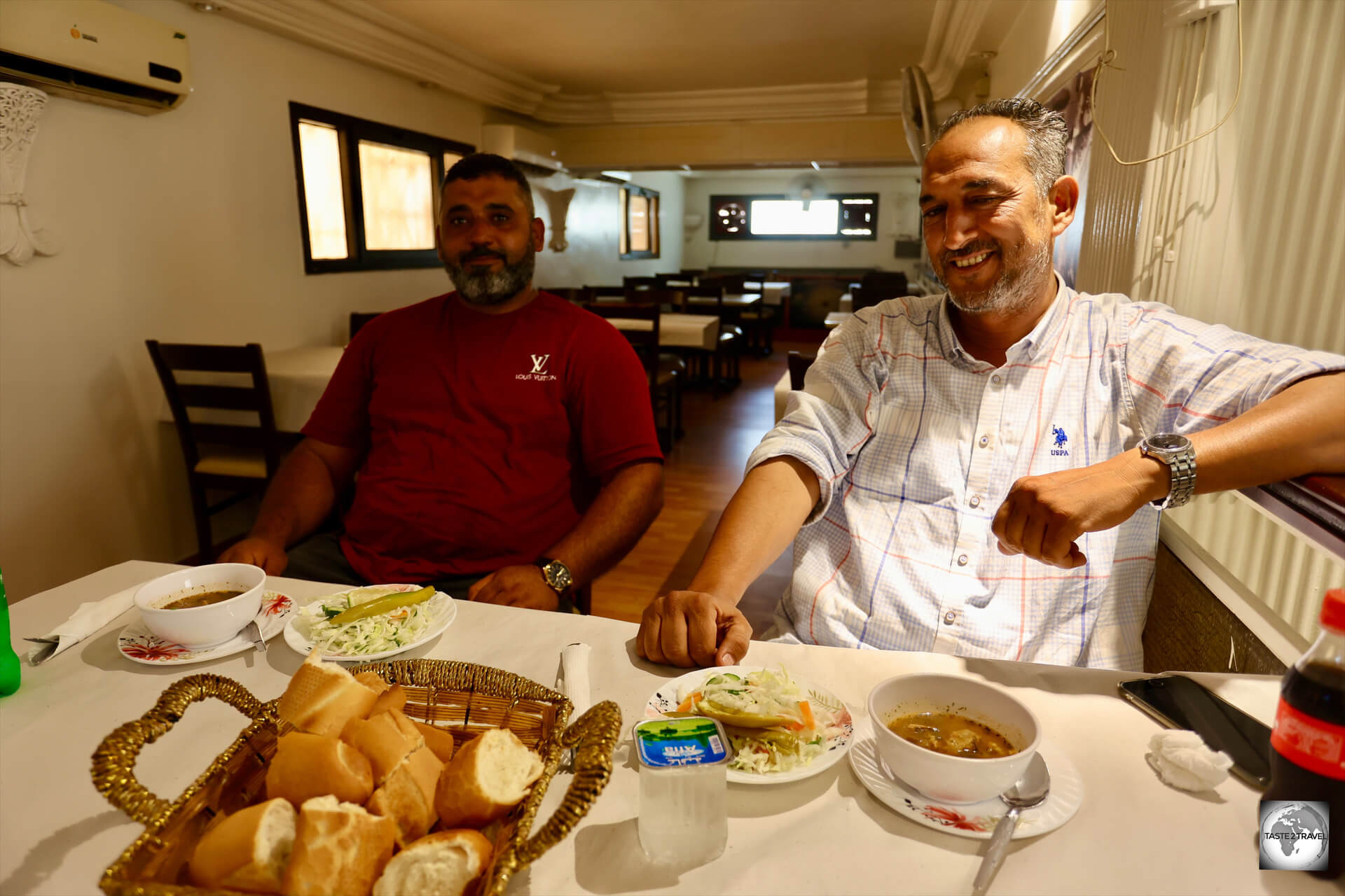 Sharing a typical Libyan meal with my guide Masoud (right) and my police escort Muhammad, who is, fittingly, slightly in the shadows.