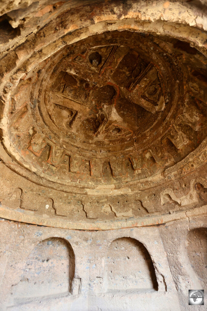 One of many niches carved into the cliff, which feature dome ceilings and carved walls.