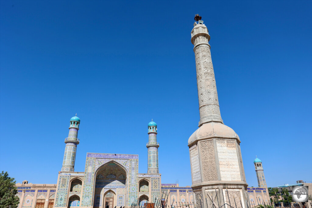 A stone memorial column is installed outside the entrance of the Great Mosque of Herat.