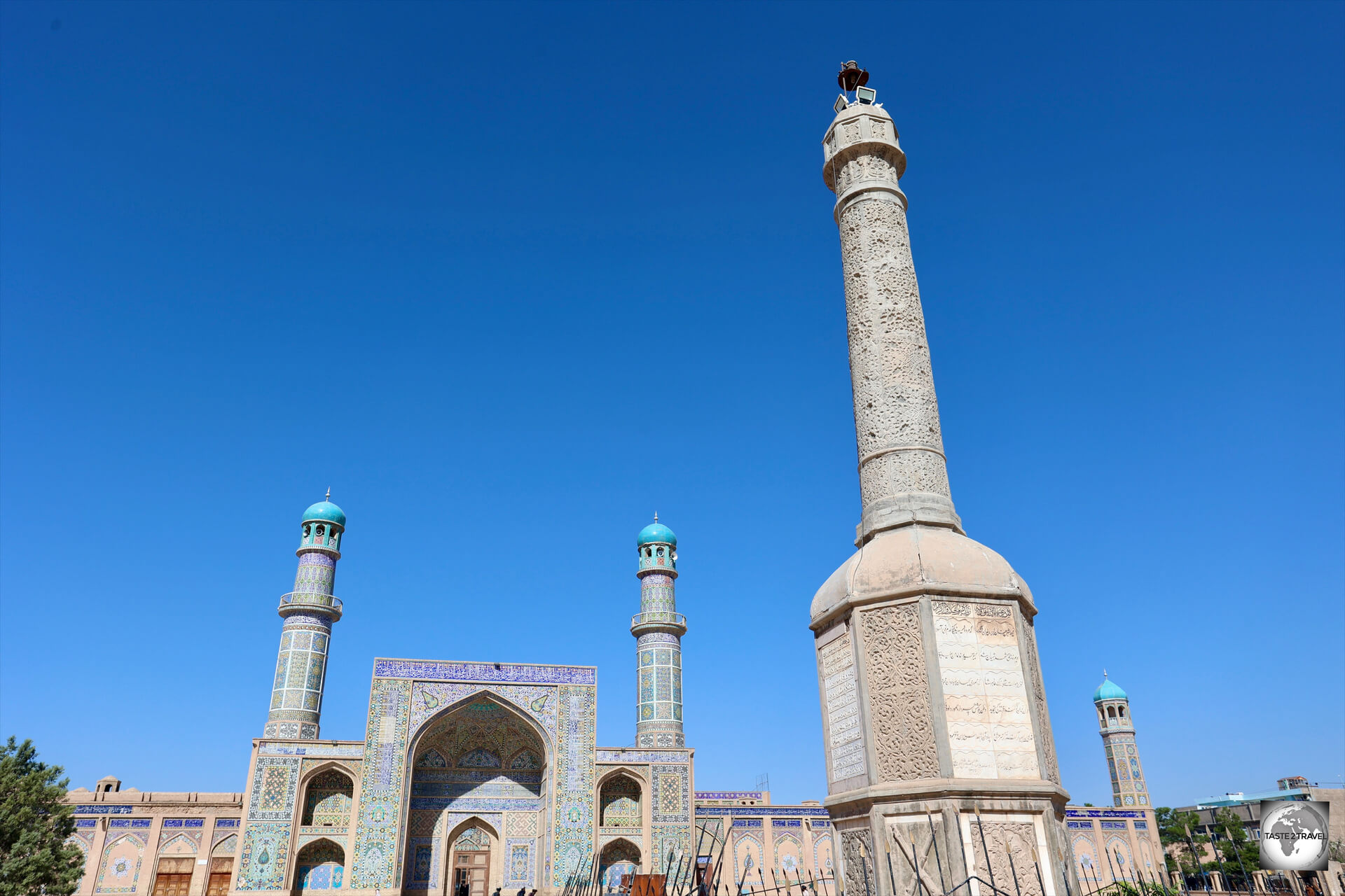 A stone memorial marker is installed outside the entrance of the Great Mosque of Herat.