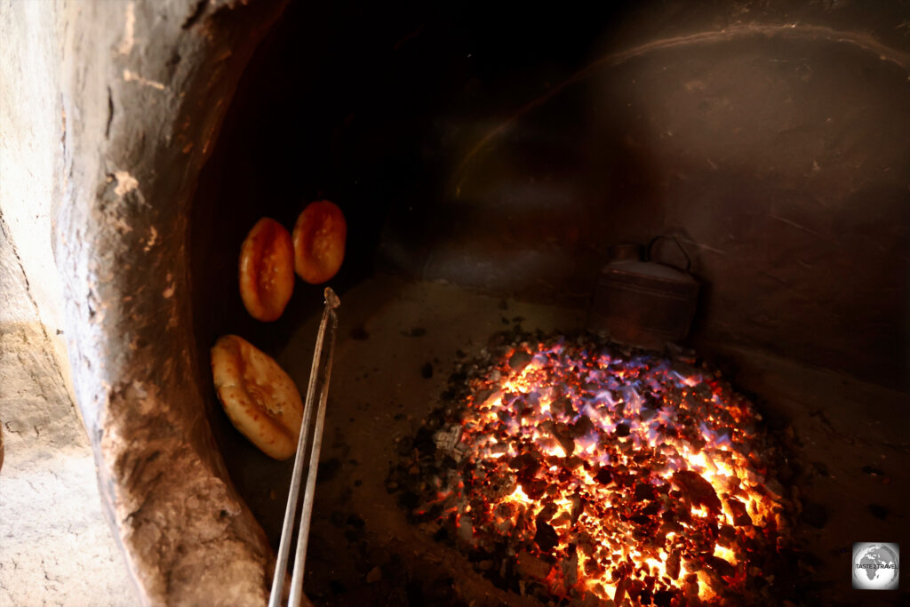 Naan Mazari baking inside a tandoor oven.