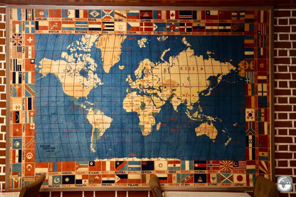 An incredible handwoven carpet in a restaurant in Mazar-i-Sharif features a map of the world.